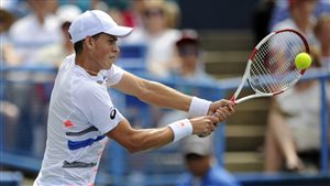 Vasek Pospisil, possessor of a backhand very similar to Raonic's, returns the Sunday. Pospisil, worn out from previous rounds, failed to mount a serious challenge against his long-time rival. Unlike Raonic, Pospisil is wearing a white cap. His mouth is slightly open.