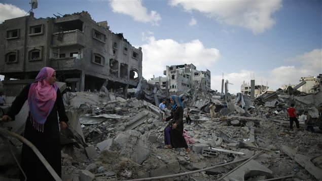 Palestinos circulan entre los escombros en la Franja de Gaza.