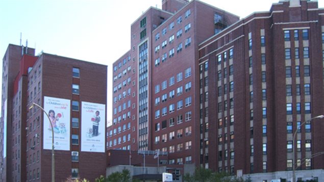 The new V-Sign app is being put to good--and full--use at the Montreal Children's Hospital, the home of some far-sighted innovation and some terrific doctors. In the photo we see the hospital from the front, sitting at the right of the picture. It rises above 12 stories with a facade of of dark-red brick. It's more block-like annex sits to the left of the main building.