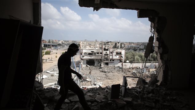 فلسطيني يسير بين ركام منزل مدمر في رفح جراء القصف الإسرائيلي