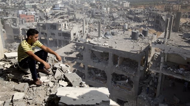 فتى فلسطيني يتأمل في آثار القصف الإسرائيلي على حيّه في غزة أوائل الشهر الفائت