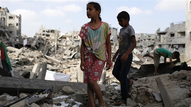 Des enfants marchent sur les ruines de l'appartement de leur famille, qui aurait été détruit selon des témoins par des raids israéliens. 