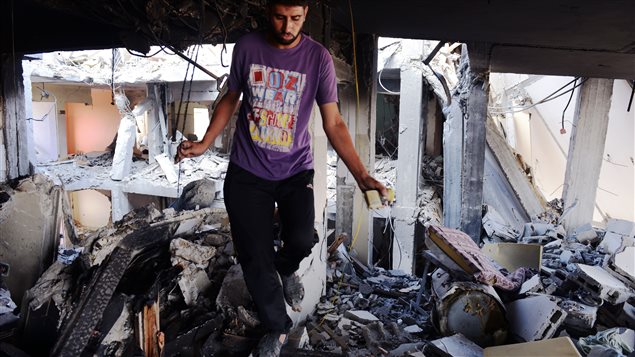 شاب فلسطيني يتفقّد منزله والدمار الذي خلّفته المواجهات الأخيرة في غزّة