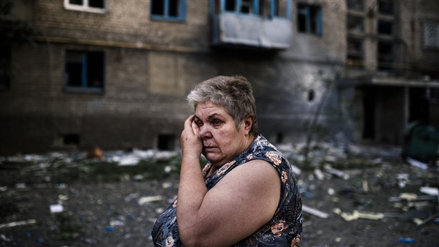 Une résidente de Yasynuvata, près de la ville de Donetsk, contrôlée par les prorusses, essuie une larme après qu'un bombardement eut fait des morts et causé d'importants dommages dans le secteur. Les résidents blâment les forces ukrainiennes. 