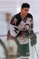 Concussions ended former NHL star Pat LaFontaine's career. We see LaFontaine in his mainly white with dark blue trim Sabres uniform. He has his stick in his left hand and a dazed and puzzled look on his face.