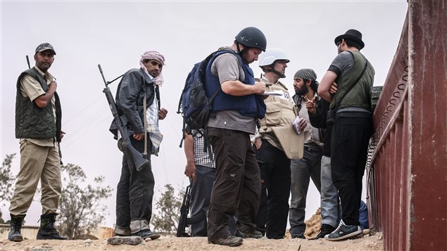 المصوّر الصحافي الأميركي الرهينة ستيفن سوتلوف( في الوسط بالخوذة السوداء) يتحدّث إلى مقاتلين في ليبيا . وقد ظهر سوتلوف في شريط الفيديو الذي يصوّر عمليّة قطع رأس الصحافي الأميركي جيمس فولي
