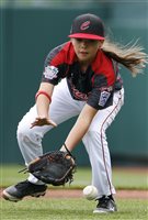 Canada's Emma March fields a grounder during warm-ups before an International pool play baseball game against Mexico at the Little League World Series. Wearing a red jersey and white trousers, Emma has her glove down and right hand in perfect position to field the grounder. Her pony tail is flying behind her.