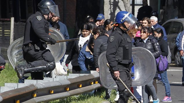 Des policiers anti-émeutes dispersent les manifestants qui ont bloqué une route lors d'une manifestation de travailleurs à Buenos Aires, mercredi.