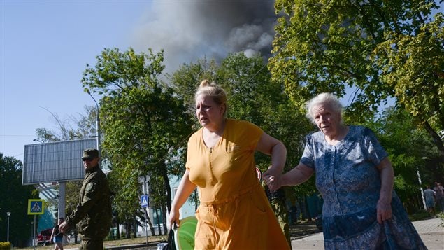 Des Ukrainiennes fuient les combats dans la ville de Donetsk.