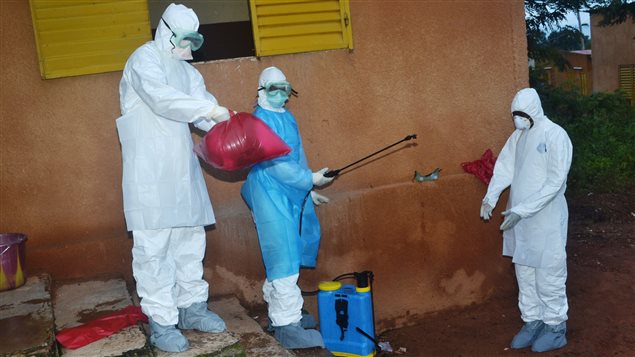 Enfermeros se preparan a retirar su ropa de protección en un hospital de Guinea. 