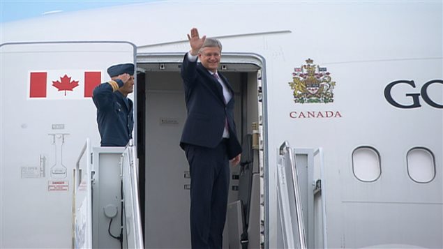 رئيس الحكومة الكندية ستيفن هاربر ملوحاً بيده اليوم قبيل دخوله الطائرة التي ستقله إلى المملكة المتحدة حيث يشارك في قمة الـ"ناتو"
