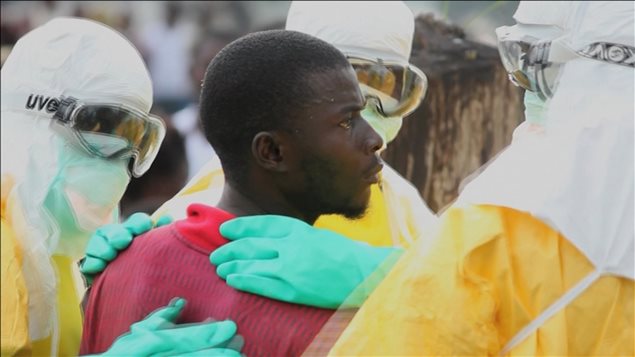 Un patient est encerclé par des médecins après avoir tenté de s'échapper de la quarantaine où il était confiné à Monrovia, au Liberia.