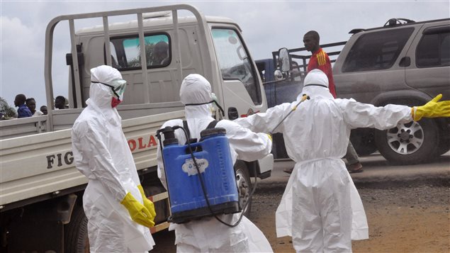 Trabajadores de la salud desinfectandose en Monrovia, Liberia. 