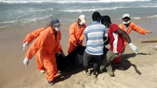 Socorristas libios recogen el cuerpo de un ahogado en la playa. 