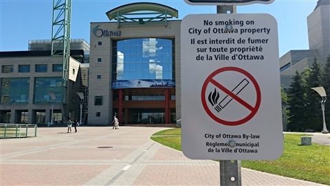 Une affiche sur laquelle on peut lire « Il est interdit de fumer sur toute propriété de la Ville d'Ottawa » est photographiée devant l'hôtel de ville d'Ottawa (archives). 