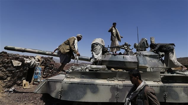 متمردون حوثيون يعاينون اليوم دبابة للجيش اليمني في مقر الفرقة الأولى المدرعة في صنعاء غداة سيطرتهم عليه