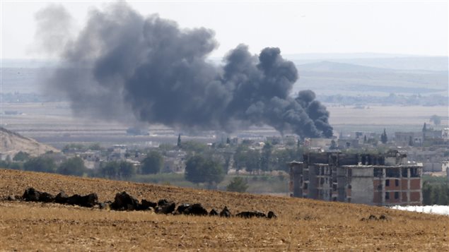 الدخان يتصاعد في مدينة عين العرب (كوباني) شمال سوريا عند الحدود التركيّة جرّاء المواجهات بين المقاتلين الأكراد وتنظيم 