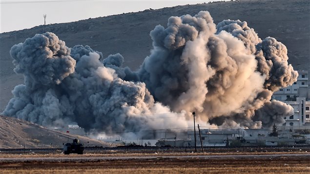 Frappe de la coalition contre le groupe État islamique à Kobané, dans le nord de la Syrie, photographiée à partir de la frontière turque.
