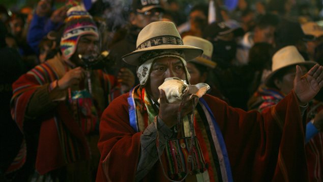 Indígena Aymará sobra un caracol para celebrar la reelección de Evo Morales.