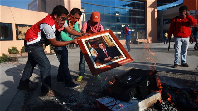 Estudiantes queman el retrato del gobernador Ángel Aguirre Rivero.