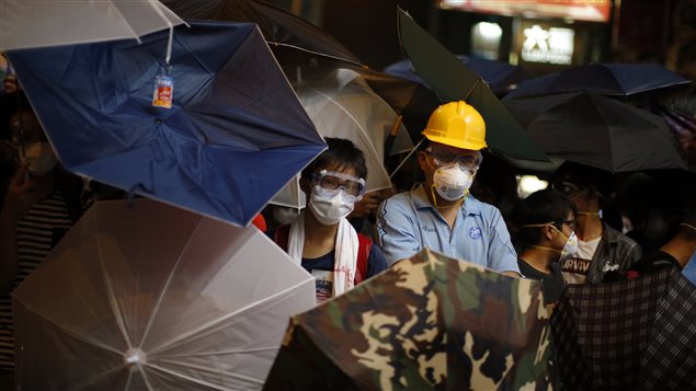 Des manifestants pro-démocrates utilisent des parapluies pour affronter la police