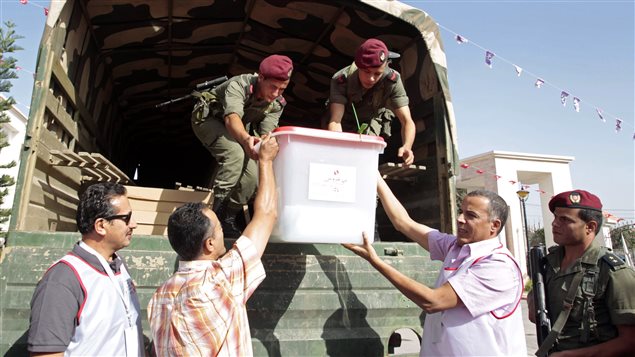 موظفون في هيئة الانتخابات التونسية يضعون صندوق اقتراع في شاحنة للجيش يوم السبت الفائت في تونس العاصمة خلال تمرين يحاكي إجراء الانتخابات التشريعية المقررة يوم الأحد المقبل