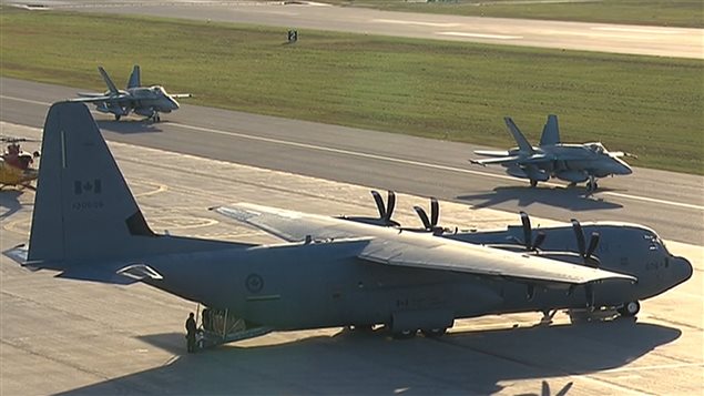 Deux chasseurs CF-18 se dirigent vers la piste de décollage de Bagotville pour s'envoler vers le Koweït.