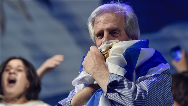 El ganador de la primera vuelta presidencial en Uruguay, Tabaré Vásquez, abraza y besa la bandera nacional poco después de conocerse los resultados, el 26 de octubre del 2014. Sin embargo, tendrá que medirse a Luis Lacalle Pou en una segunda vuelta, el 30 de noviembre. 