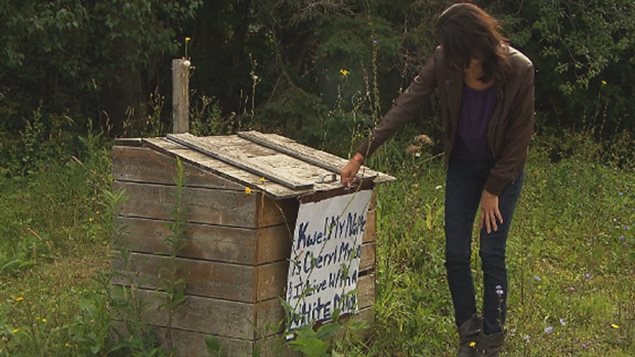 Kahnawake resident Cheryl Diabo looks over the sign left anonymously in August 2014, declaring she lives with a 'White Man'.  She opposes the intention to evict non-native residents.