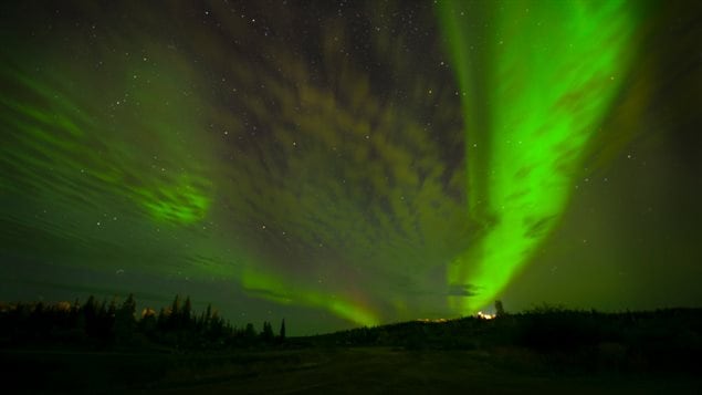 Green northern lights over an Arctic landscape.