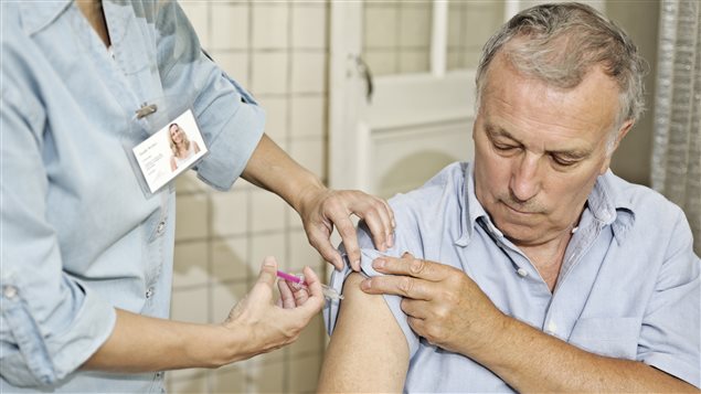 Une infirmière injecte un vaccin à un patient Une infirmière injecte un vaccin à un patient