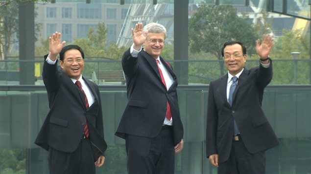 Le premier ministre canadien Stephen Harper encadré par des représentants du gouvernement chinois.