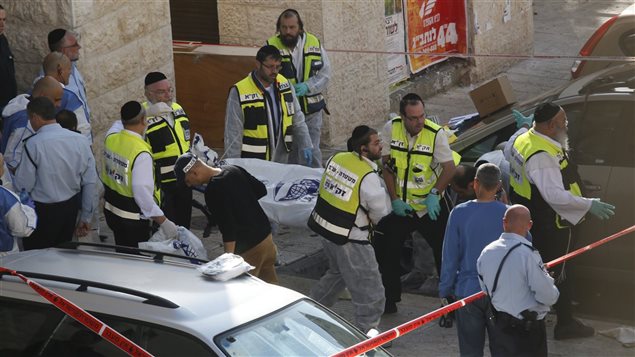 فرق الاسعاف الاسرائيليّة تسحب جثّة فلسطيني أردته الشرطة بعد أن  شارك في الهجوم على كنيس في القدس  في 18 تشرين الثاني نوفمبر 2014