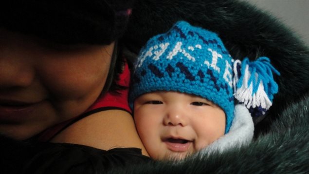 Makibi Timilak sits in his mother’s fur-line coat. The family formally requested a coroner’s inquest after the baby died in 2012.