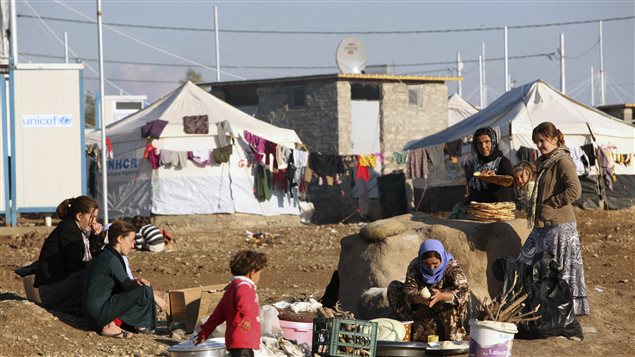 نساء إيزيديات من مدينة سنجار في شمال غرب العراق يقمن بإعداد الخبز يوم السبت الفائت في مخيم خانكي للاجئين في محافظة دهوك في كردستان العراق