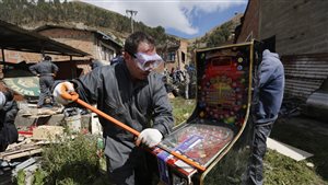 Dismantling pinball machines in La Paz, Bolivia on Nov. 28th,  The government  began the nationwide destruction of thousands of slot machines and gambling tables confiscated from operators due to irregularities within the machines themselves and/or the illegal placement of the gambling equipment. Many were found to be operating near schools and attracting children to play.