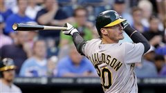  The Jays are hoping Josh Donaldson can provide some pop at the plate and steady defence at third base this season. We see Donaldson completing his backswing after a hit in an green and grey Oakland uniform. His black bat held in his back (left) hand is extended behind him.