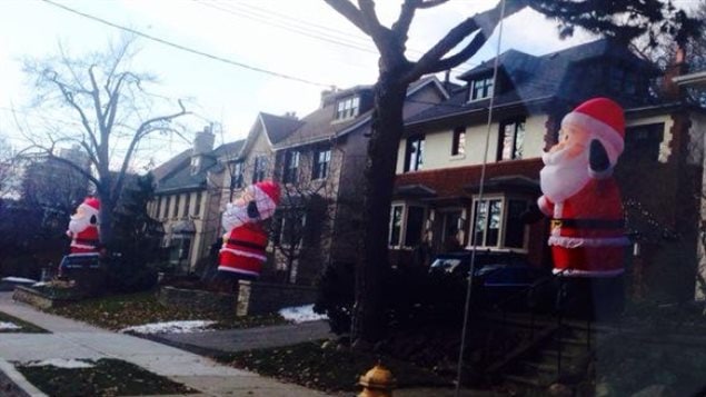 Trois des 45 Pères Noël gonflabes de six mètres le long d'Inglewood Drive à Toronto 