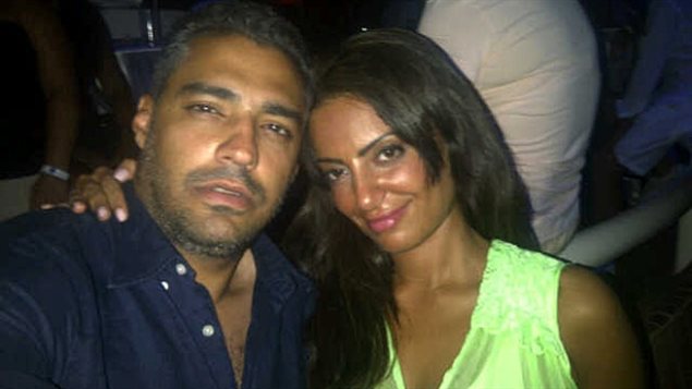 Mohamed Fahmy and his fiancee of two years, Marwa Omara, in an undated photo. Seated on the left of the photo, Mr. Fahmy has on a dark blue shirt and wears a serious expression. He is a handsome man with greying, wavy hair. She has her right arm around his shoulder and is wearing a yellow dress and the expression of someone very much in love.