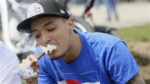 Un jeune homme fume un joint dans un parc de Denver au Colorado en 2013.