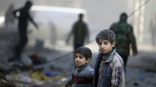 En uno de los barrios de Damasco, dos niños caminan luego de un ataque aéreo al parecer perpetrado por las fuerzas del presidente Bachar al-Assad.