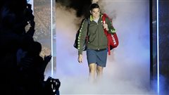 Milos Raonic arrives to play Roger Federer in their ATP World Tour Finals tennis match at the O2 Arena in London in November. Raonic appeared over matched, but continues move up the rankings. We see Raonic with his red equipment bag slung over his left shoulder wearing a brown warm-up jacket and dark blue pants. He is emerging from a tunnel surrounded by dry ice steam.