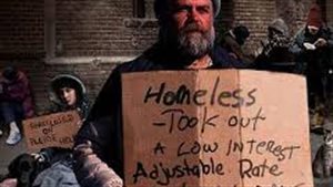Thousands of Canadians battle the effects of poverty every day. We see a man holding a sign on a cardbord carton. The sign reads: