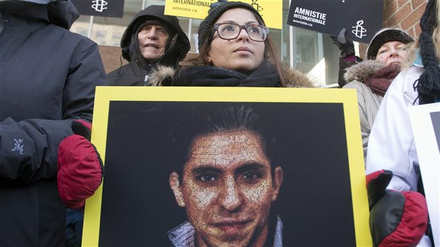 La femme de Raif Badawi, Ensaf Haidar, tient une photo de son mari lors d'une manifestation pour demander sa libération le 13 janvier 2015, à Montréal.  