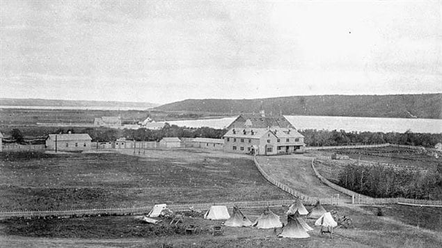 L’école industrielle pour Amérindiens de Fort Qu'Appelle en Saskatchewan, 1885. Des chariots de la Rivière Rouge et des tipis en avant plan 