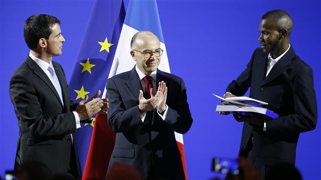 Lassana Bathily recibiendo la ciudadanía francesa de manos del primer ministro, Manuel Valls, y del ministro del Interior, Bernard Cazeneuve. 