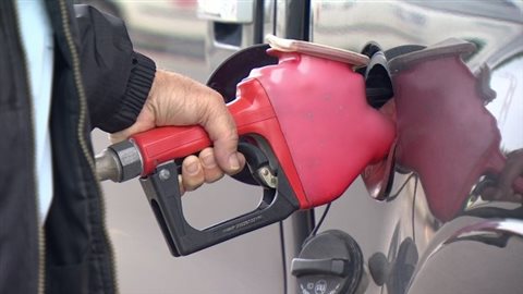 Un automobiliste fait le plein d’essence.