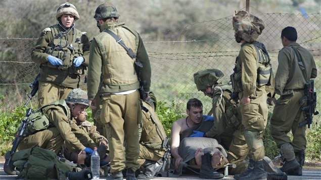 جنود إسرائيليون يساعدون جنديا جريحا على الحدود اللبنانية الإسرائيلية