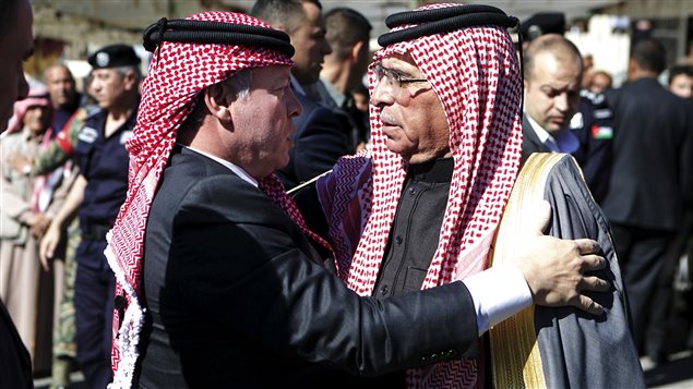 العاهل الأردني الملك عبد الله الثاني (إلى اليسار) معزياً صافي الكساسبة بابنه الطيار معاذ اليوم في مدينة الكرك جنوب عمّان
