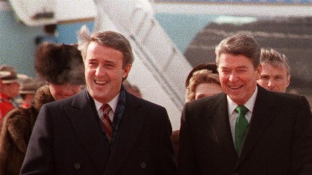 رئيس الحكومة الكندية برايان مالروني (إلى اليسار) مستقبلاً الرئيس الأميركي رونالد ريغان عند وصوله إلى مطار كيبيك في 17 آذار (مارس) 1985.